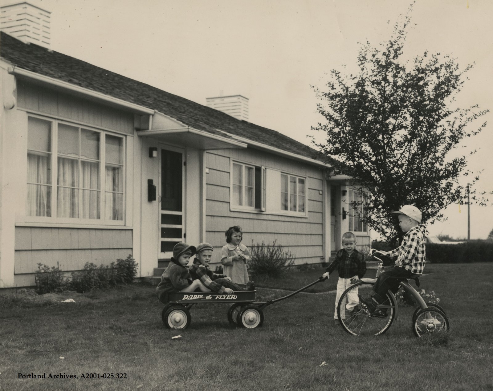 1944_children-playing-with-a-wagon-and-tricycle-outside-an-apartment-row_a2001-025-322.jpg