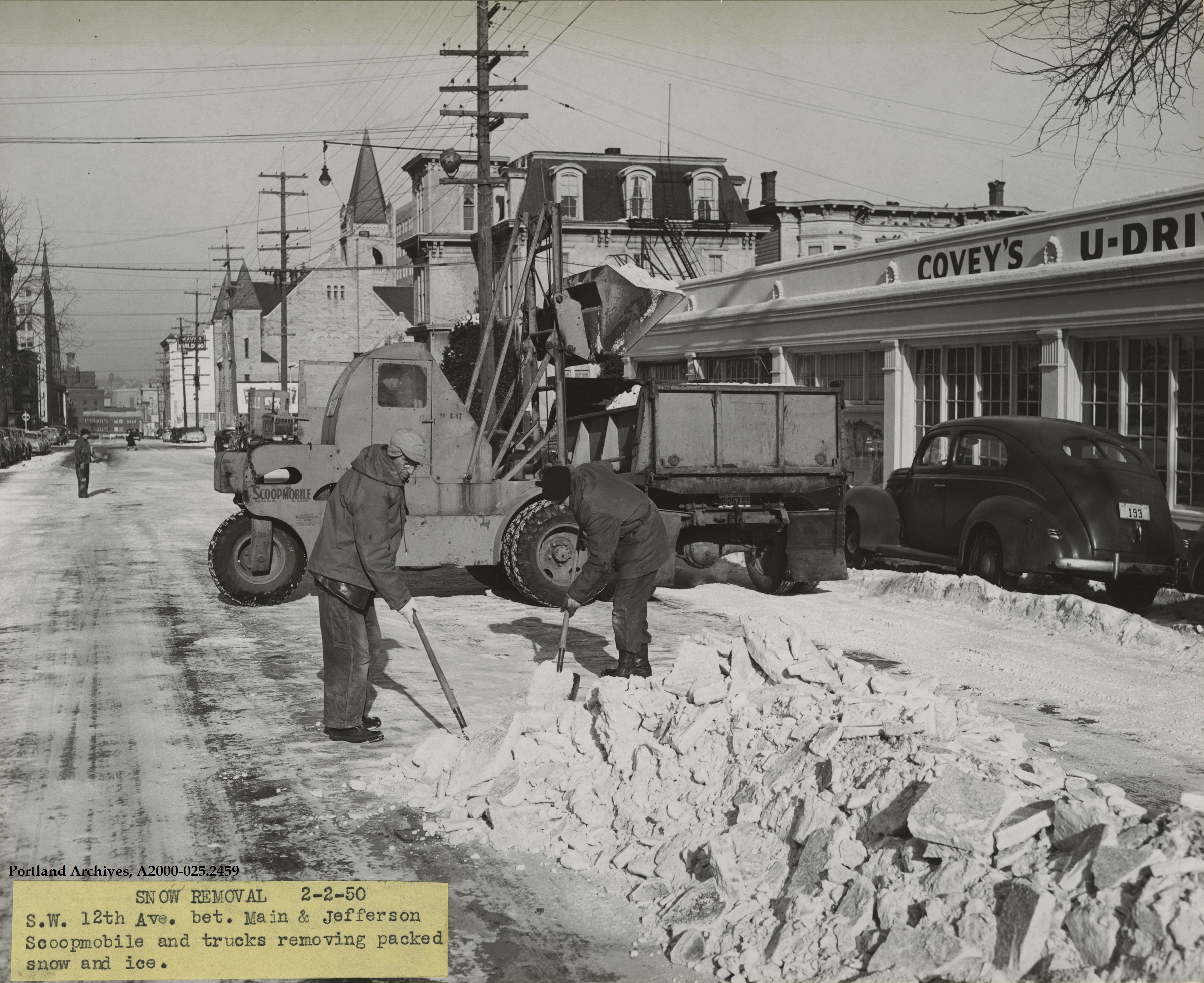 1950-feb-2_crew-by-trucks-and-scoopmobile-for-snow-removal-on-sw-12th-ave-between-main-.jpg