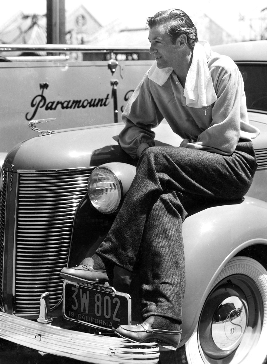 Gary Cooper sits on the fender of his De Soto on the Paramount lot, 1937.jpg