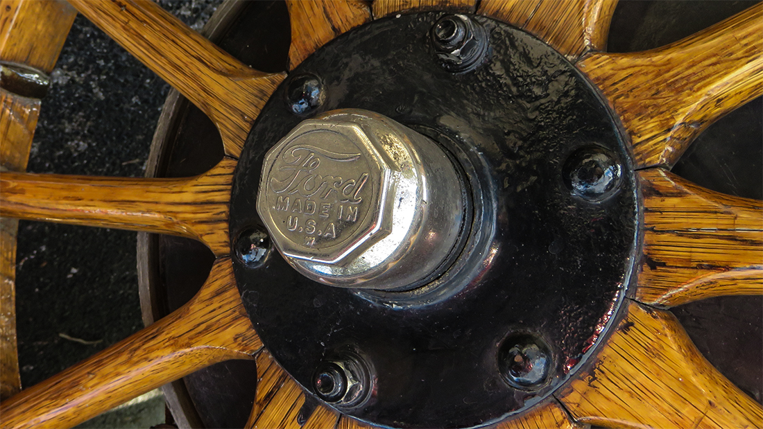 Hub-cap-Ford-Made-in-USA-W-on-wooden-spoked-tire-on-Model-T-Ford.jpg