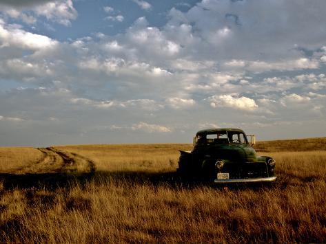 kenneth-ginn-a-landscape-of-an-old-farm-truck-in-a-field-at-sunset.jpg