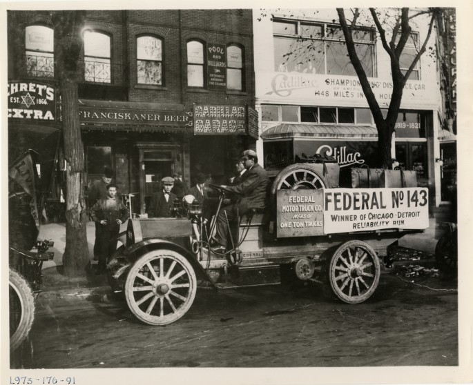 one ton Federal truck is parked in front of a Cadillac dealer and garage.jpg