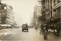 a woman crossing Woodward Ave. Grinnell Bros. store  Vernor\'s truck.JPG