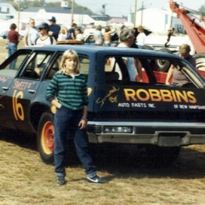 The kids with the demolition derby car , I drove this car to work for several years in stock condition. Note toilet seat escape hatch on roof . Repaint & flames by Tim Dube who also drove it in the competition. This is the Before race . The After race image is not a pretty sight