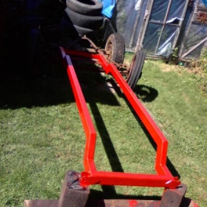 Needed to set the frame outside for a while and since the rust starts in mnutes... I brushed on some pretty, temporary urethane.
NO it will NOT stay orange.
Yes it is upside down. ;)
Also... got the shock mounts on the back.