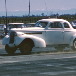 GeriTarvin '37buick-  picture taken at Lodi calif (Kingdon) 1960
this car had a Buick str8-8 was F/gas class winner at Bakersfield 1960, featured 6 carbs, vertex magneto modified from a Dodge Hemi, 8 into one tube exhaust, ya can see the dust being blown up by the exhaust.