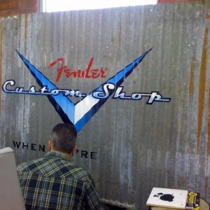 Todd hand painting a custom sign for Fender Guitars