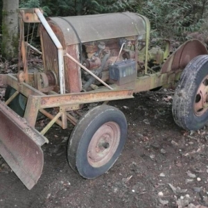 Homemade tractor.  Was built in 1941, by the high school shop teacher in Sedro Woolley, Wa.  Model A engine/3-sp trans, with 2 rearends.  Note the homemade cable lift for the blade.  Also, no lug bolts holding the rim on.  Those wheels have two centers.  The inside one bolts to the hubs.