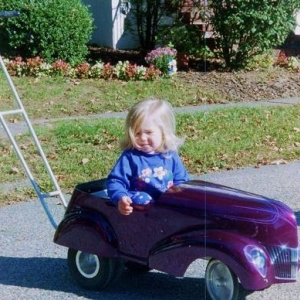 my niece kelsie in a peddle car/stroller I built