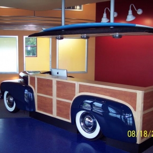 The front clip and rear fender of the desk are real, the rest of the body is cabinet work to look like a woodie. The lighted over hang above the desk has the planked "headliner" look of the woodie and the vinyl top complete with a surf board I carved from a blank and fiberglassed.