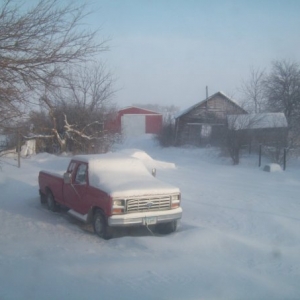 The El Camino is almost buried in the snow behind the pickup.