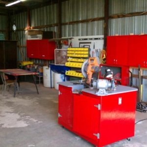 Looking north-east from the main doors of shop

I built that rolling cabinet for my chop saw & grinder - it was supposed to also hold a benchtop drill press, but I didn't plan properly and it is not wide enough to hold it and allow a full 45 degree rotation of stock to be cut by the saw.